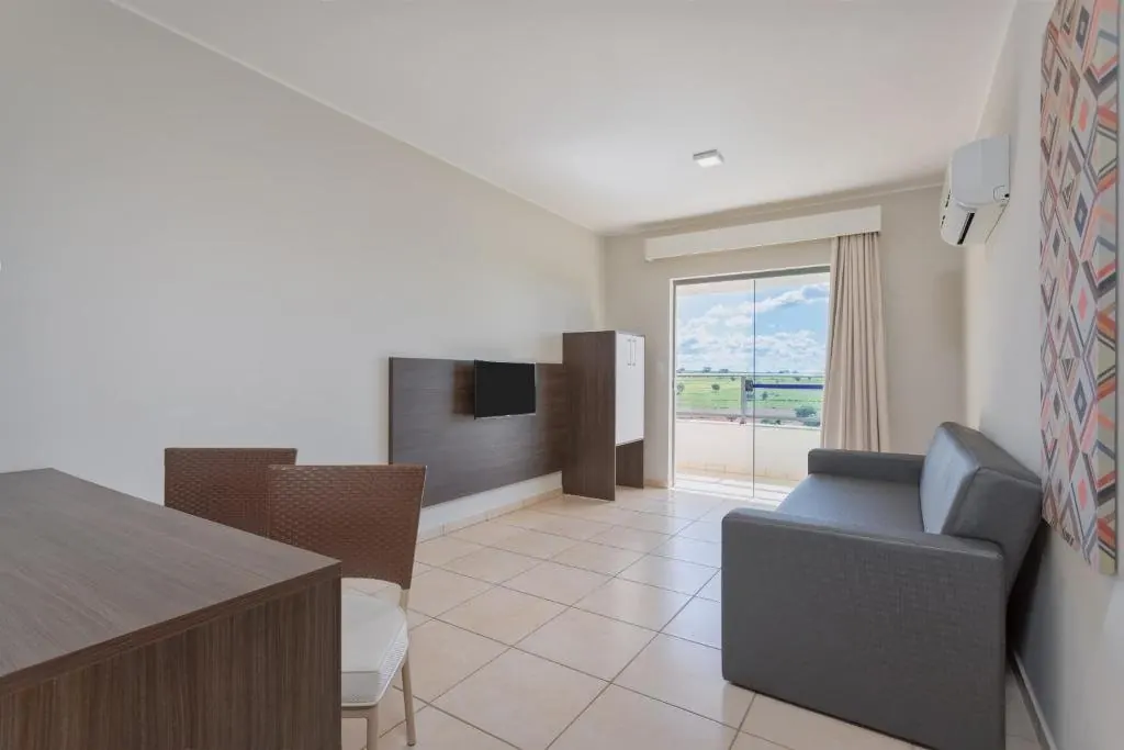 Acomodação com sofá, TV e mesa de trabalho
