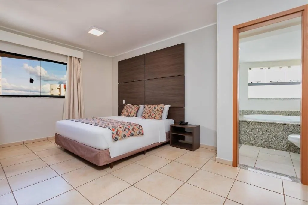 Quarto com cama de casal e banheiro