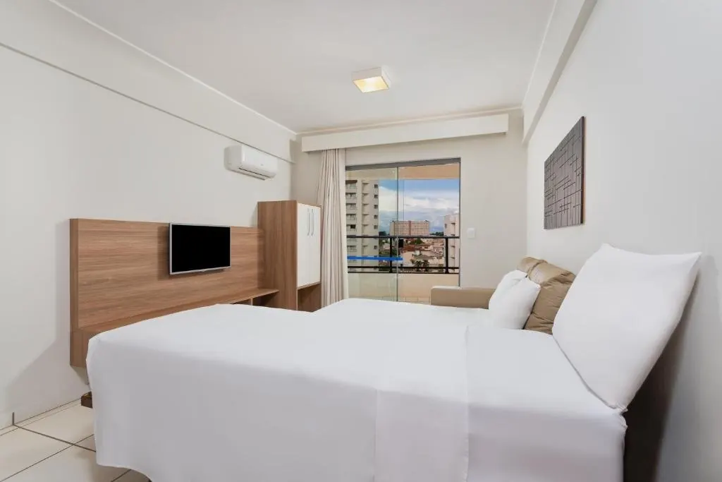 Quarto com cama de casal e janela ampla